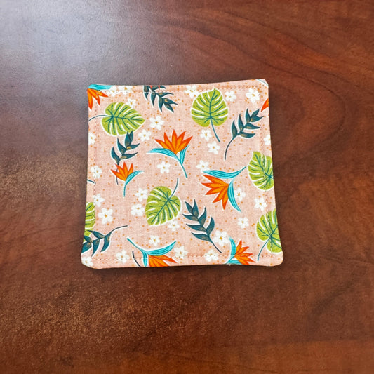 Elevate your space with this playful 100% cotton tropical coaster. Featuring a vibrant and stylish tropical print, this coaster brings a touch of tropical flair and fun to your home. Crafted with an absorbent cotton batting layer inside, it's designed to soak up condensation and protect your furniture from unsightly water rings and spills. Perfect for coffee mugs, glasses, or teacups, this durable and machine-washable coaster is a delightful addition to your kitchen or living room. Elevate your home decor w