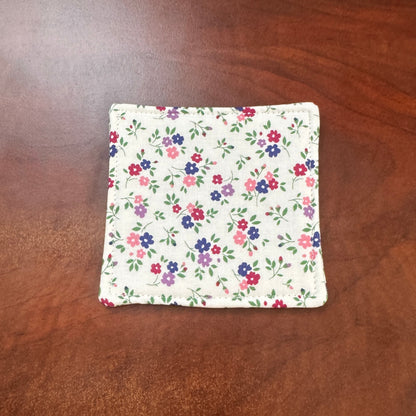 Elevate your space with this playful 100% cotton white floral coaster. Featuring a vibrant and stylish floral print, this coaster brings a touch of floral and fun to your home. Crafted with an absorbent cotton batting layer inside, it's designed to soak up condensation and protect your furniture from unsightly water rings and spills. Perfect for coffee mugs, glasses, or teacups, this durable and machine-washable coaster is a delightful addition to your kitchen or living room. Elevate your home decor with th
