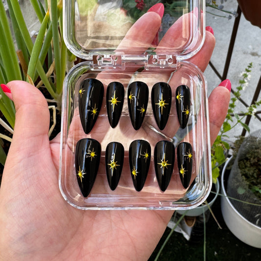 Get ready for "The Witching Hour" with these stunning, celestial press-on nails. Featuring a mysterious, deep black base and shimmering gold stars, this set captures the magic of a midnight sky. Each set is a miniature work of art, meticulously designed and hand-painted, adding a unique flair to any occasion. No time for salon appointments? Say hello to instant glamour that’s ready whenever you are. Our durable, high-quality press-ons offer a flawless, comfortable fit and are designed to last.