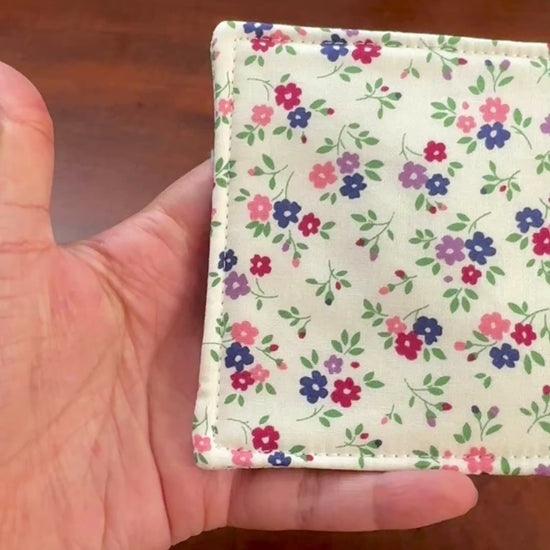 Elevate your space with this playful 100% cotton white floral coaster. Featuring a vibrant and stylish floral print, this coaster brings a touch of floral and fun to your home. Crafted with an absorbent cotton batting layer inside, it's designed to soak up condensation and protect your furniture from unsightly water rings and spills. Perfect for coffee mugs, glasses, or teacups, this durable and machine-washable coaster is a delightful addition to your kitchen or living room. Elevate your home decor with th