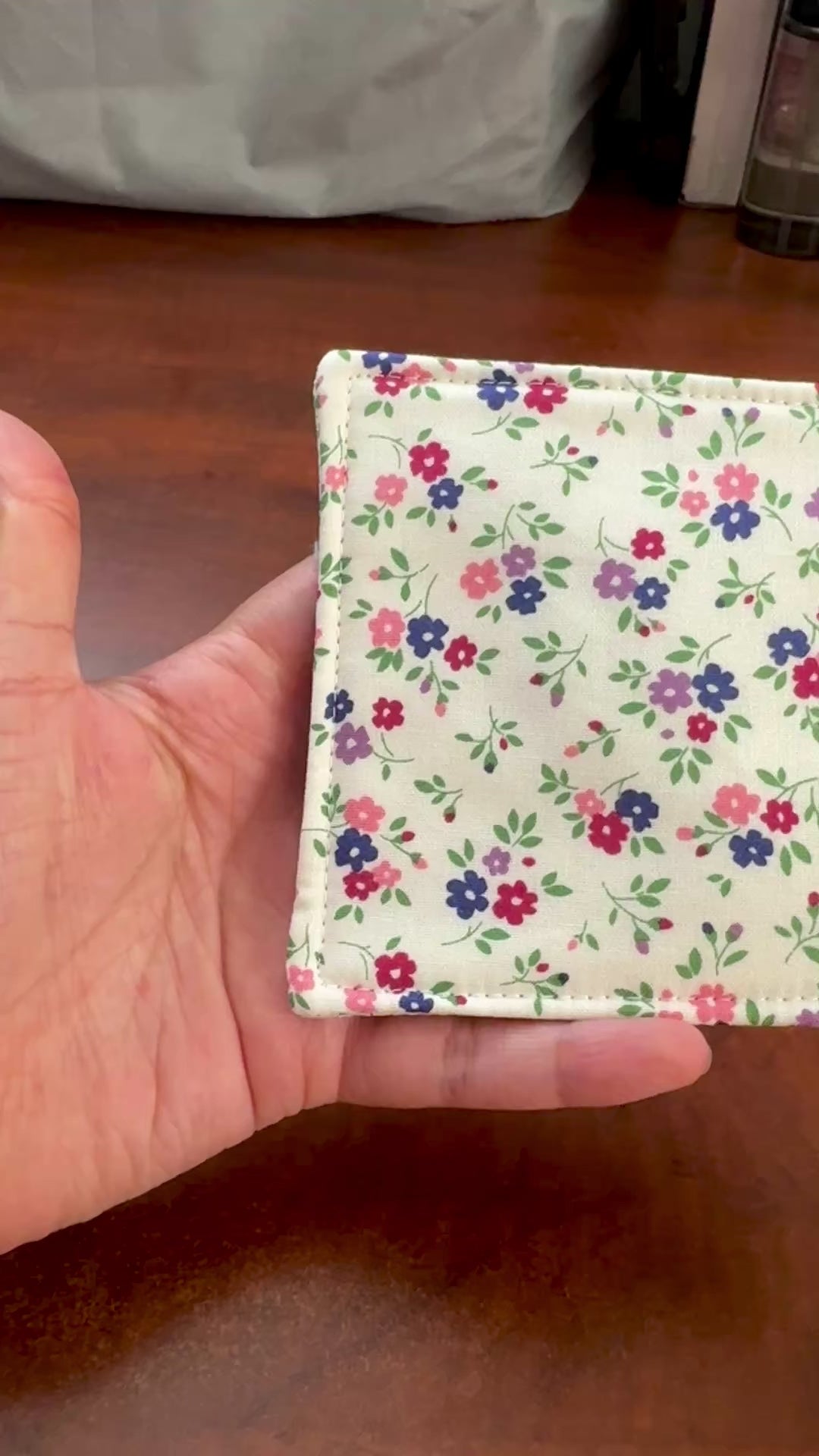 Elevate your space with this playful 100% cotton white floral coaster. Featuring a vibrant and stylish floral print, this coaster brings a touch of floral and fun to your home. Crafted with an absorbent cotton batting layer inside, it's designed to soak up condensation and protect your furniture from unsightly water rings and spills. Perfect for coffee mugs, glasses, or teacups, this durable and machine-washable coaster is a delightful addition to your kitchen or living room. Elevate your home decor with th