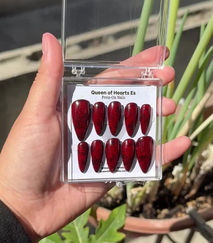 Get ready for "The Temptress" and embrace dark glamour with these stunning handmade press-on nails, featuring a rich dark base and delicate, red lace design.&nbsp;
