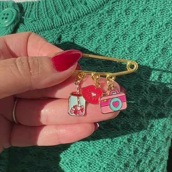 Elevate your Valentines Day or Galentines Day with this adorable gold iron pin brooch featuring coffee, lips, and a camera enamel charms. Perfect for adding a touch of love to any outfit.