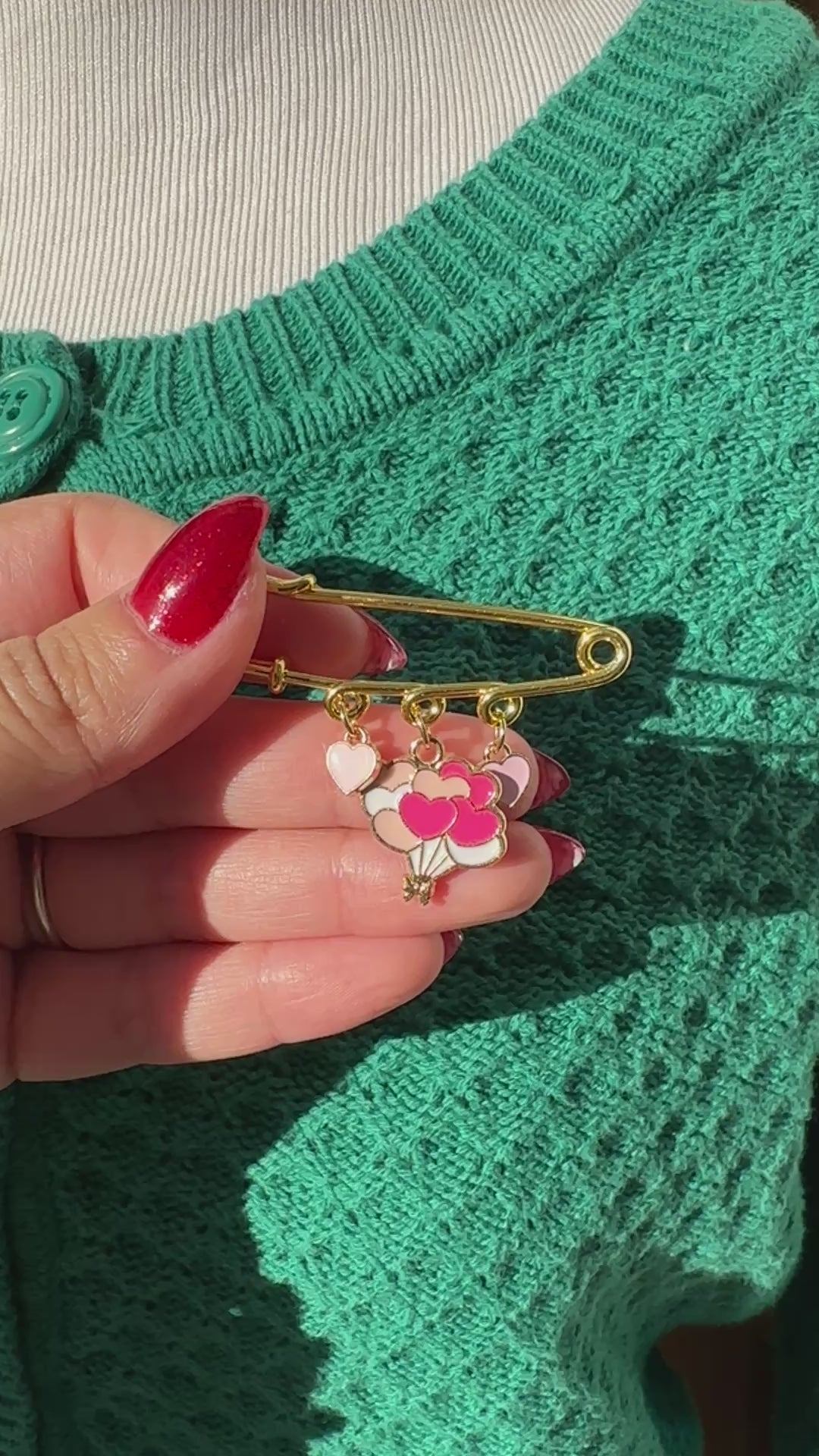 Elevate your Valentines Day or Galentines Day with this adorable gold iron pin brooch featuring heart balloons enamel charms. Perfect for adding a touch of love to any outfit.