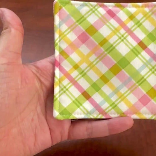 Elevate your space with this playful 100% cotton pink and green plaid coaster. Featuring a vibrant and stylish pink and green plaid print, this coaster brings a touch of retro fun to your home. Crafted with an absorbent cotton batting layer inside, it's designed to soak up condensation and protect your furniture from unsightly water rings and spills. Perfect for coffee mugs, glasses, or teacups, this durable and machine-washable coaster is a delightful addition to your kitchen or living room. Elevate your h
