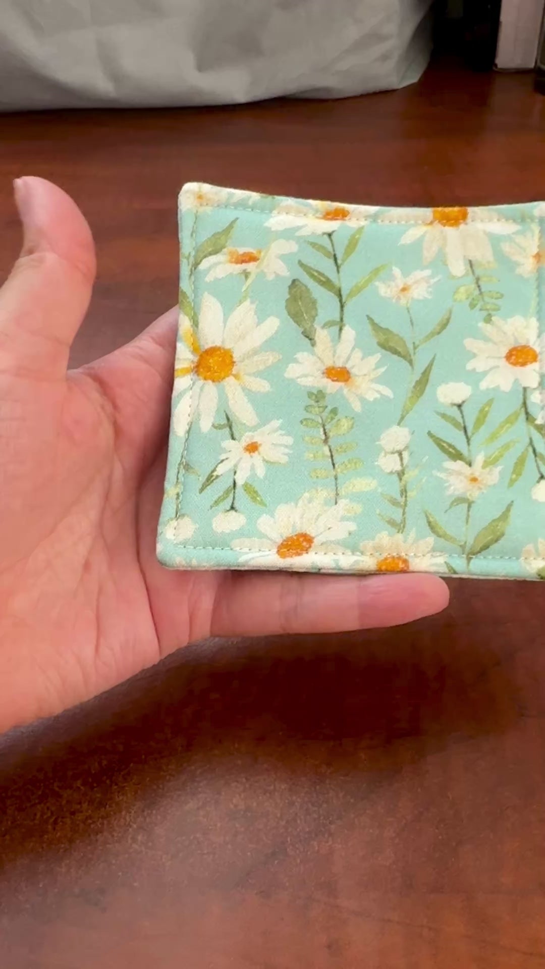 Elevate your space with this playful 100% cotton daisy coaster. Featuring a vibrant and stylish daisy print, this coaster brings a touch of tropical flair and fun to your home. Crafted with an absorbent cotton batting layer inside, it's designed to soak up condensation and protect your furniture from unsightly water rings and spills. Perfect for coffee mugs, glasses, or teacups, this durable and machine-washable coaster is a delightful addition to your kitchen or living room. Elevate your home decor with th