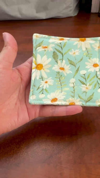 Elevate your space with this playful 100% cotton daisy coaster. Featuring a vibrant and stylish daisy print, this coaster brings a touch of tropical flair and fun to your home. Crafted with an absorbent cotton batting layer inside, it's designed to soak up condensation and protect your furniture from unsightly water rings and spills. Perfect for coffee mugs, glasses, or teacups, this durable and machine-washable coaster is a delightful addition to your kitchen or living room. Elevate your home decor with th