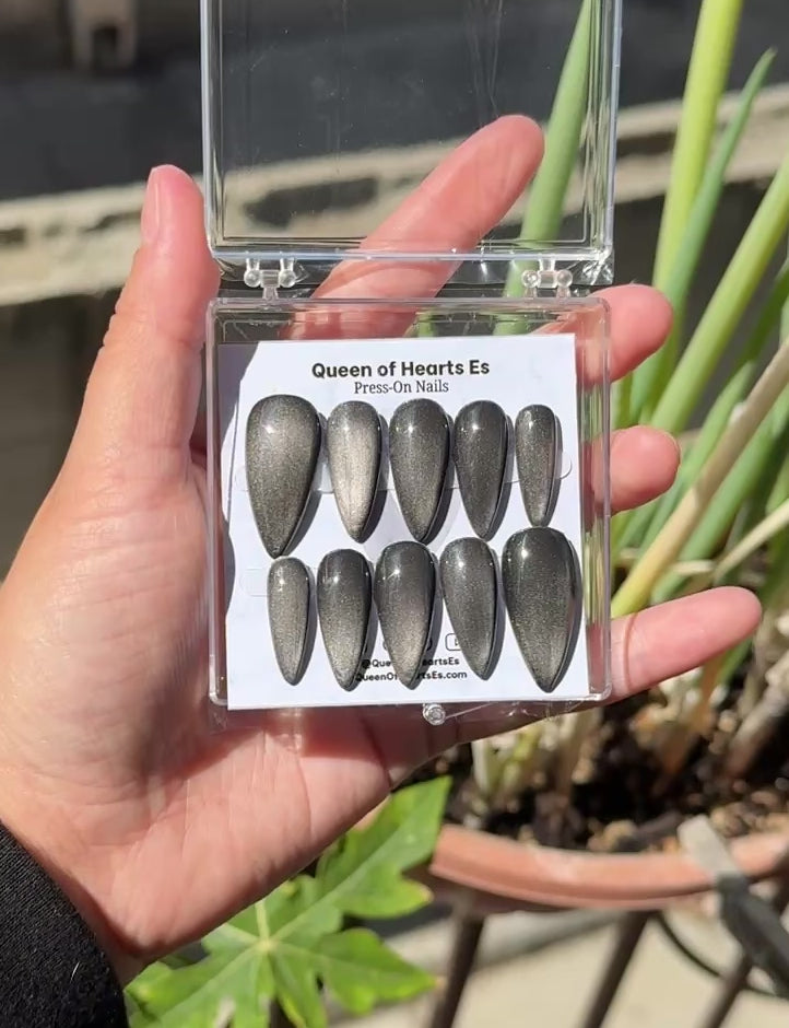 Get ready for "The Apparition" and embrace dark glamour with these stunning handmade press-on nails, featuring a silver cat eye base and delicate, reflective design.